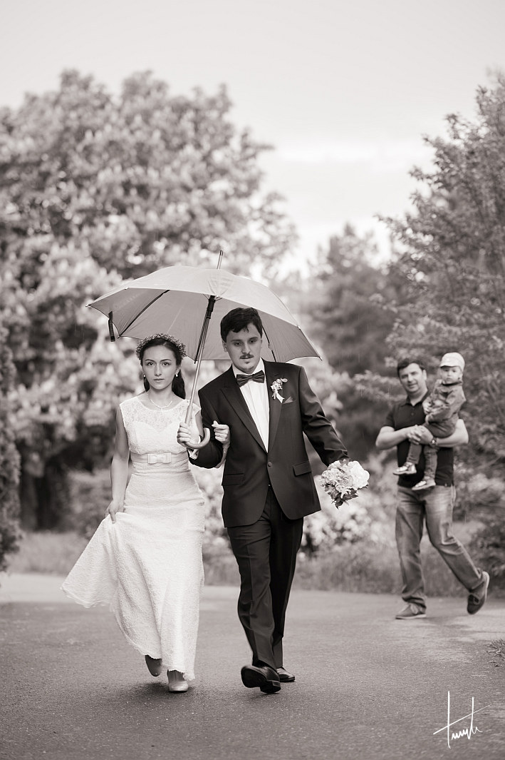 cuplu mergand prin ploaie in ziua nuntii